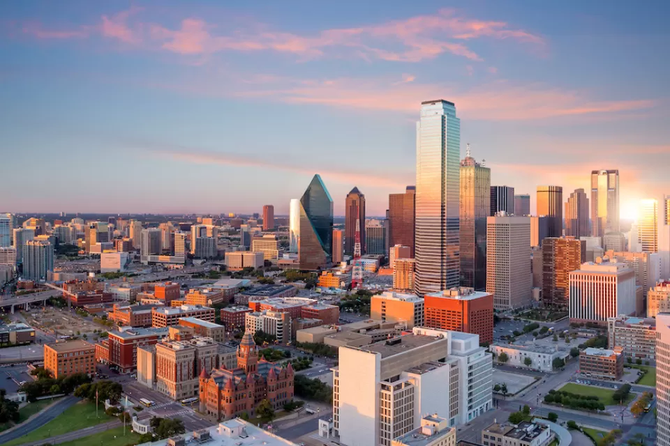 View of downtown Dallas, Texas skyline with skyscrapers against twilight sky.